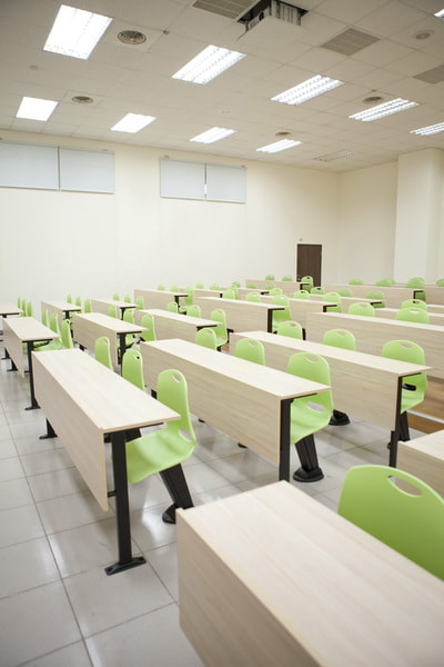 training room with auto-return green plastic chairs and fix table
