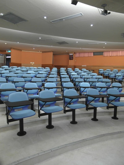 Fix chair blue plastic and light blue fabric with writing tablet for auditorium room