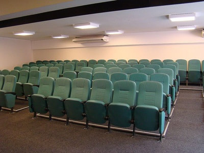 strong auditorium chairs fully upholstered in green fabric in Tyr