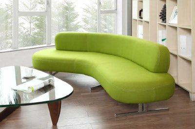 lounge sofa upholstered in green fabric arc shape in chrome legs and glass side table